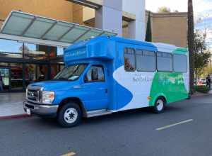 A Santa Clarita Transit Dial-a-Ride bus picking up passengers at the food court of Westfield Town Centre.