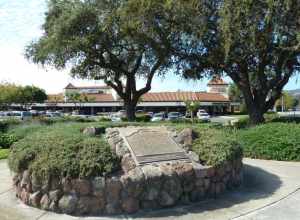 Bronze interpretive plaques and oak trees at site of 21-Mile House, a 19th-century inn and stage coach stop, at intersection of Monterey Street and Tennant Avenue in Morgan Hill, Santa Clara County, California, U.S.A.  California Registered Historic